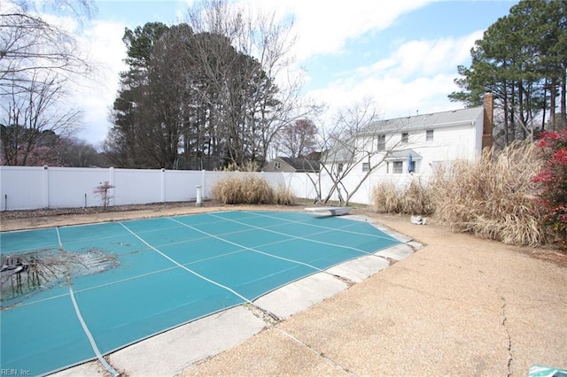 view of swimming pool featuring a fenced in pool, a fenced backyard, and a diving board