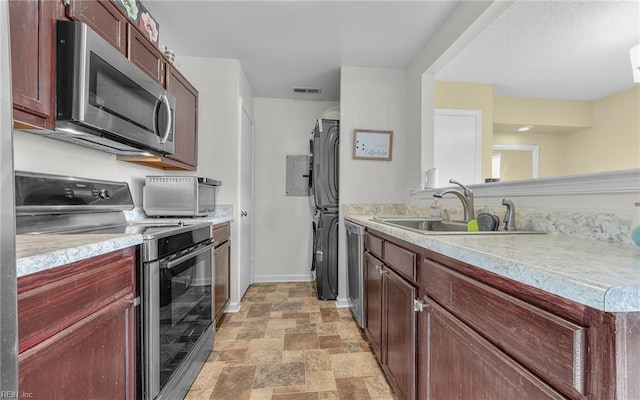 kitchen with visible vents, stone finish floor, a sink, stainless steel appliances, and light countertops