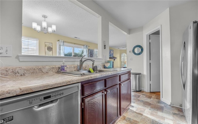 kitchen featuring a sink, stainless steel appliances, light countertops, stone finish floor, and reddish brown cabinets