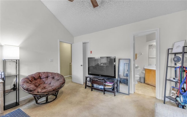 living area featuring a textured ceiling, baseboards, light colored carpet, ceiling fan, and vaulted ceiling