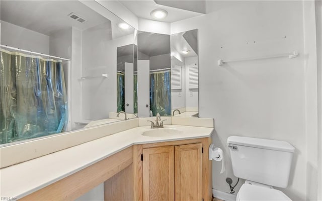 bathroom featuring visible vents, toilet, vanity, and a shower with curtain