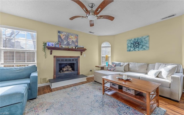 living room featuring visible vents, a healthy amount of sunlight, and wood finished floors