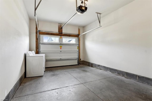 garage featuring separate washer and dryer, a garage door opener, and baseboards