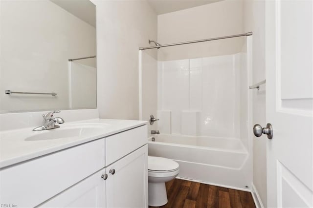 full bath featuring washtub / shower combination, toilet, wood finished floors, and vanity