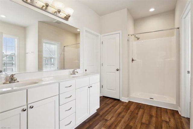 bathroom featuring a sink, walk in shower, and wood finished floors