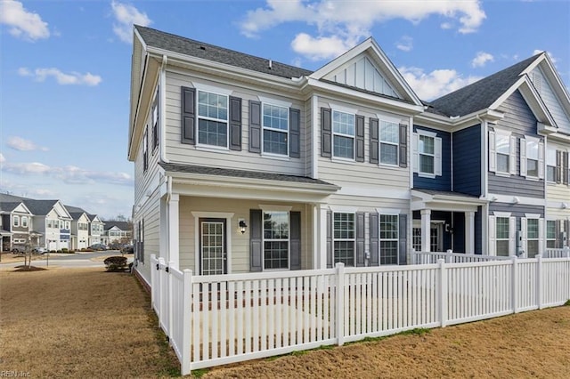 view of front of home featuring board and batten siding, fence, covered porch, and a residential view