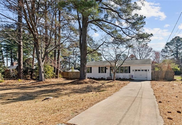 ranch-style home with driveway, an attached garage, and fence