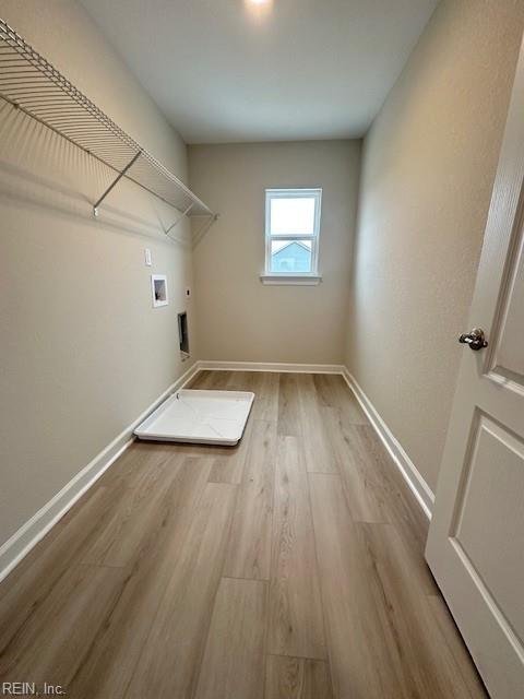 laundry room with baseboards, light wood finished floors, laundry area, electric dryer hookup, and washer hookup