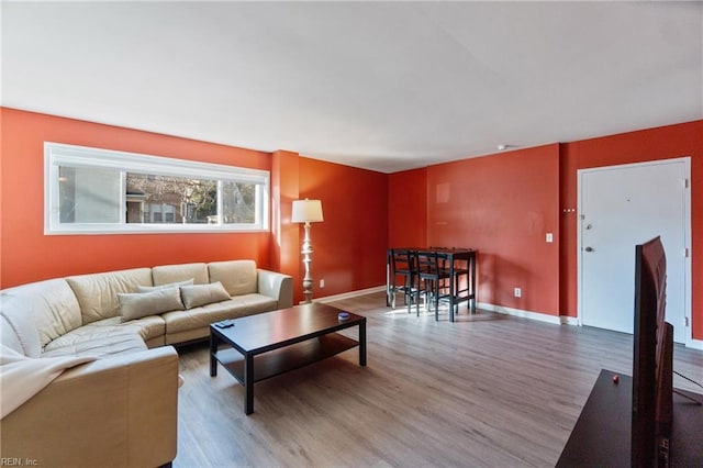 living area with baseboards and wood finished floors