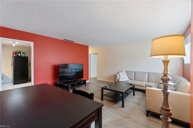 living room featuring visible vents and light wood-style flooring