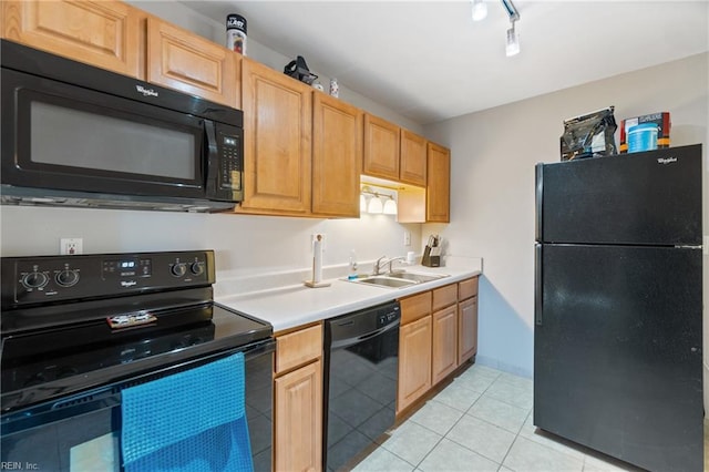 kitchen with track lighting, light countertops, light tile patterned floors, black appliances, and a sink