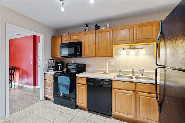 kitchen with light tile patterned floors, black appliances, light countertops, and a sink