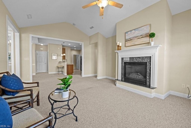 living area featuring lofted ceiling, carpet, a premium fireplace, baseboards, and ceiling fan