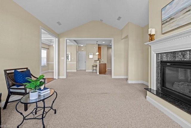 living area featuring visible vents, baseboards, lofted ceiling, a high end fireplace, and carpet flooring