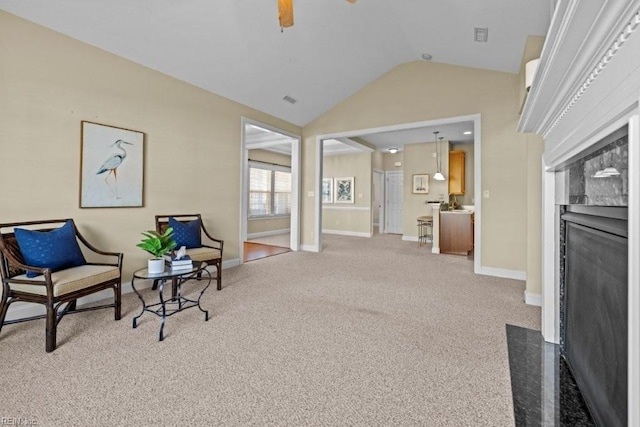 sitting room with visible vents, lofted ceiling, carpet floors, baseboards, and ceiling fan