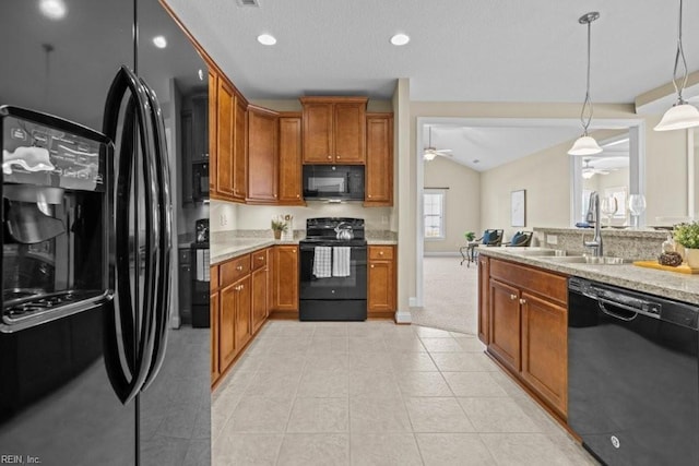 kitchen with brown cabinets, black appliances, a ceiling fan, a sink, and vaulted ceiling