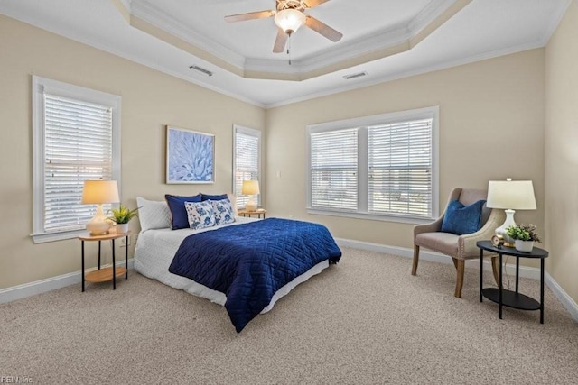 carpeted bedroom with visible vents, a raised ceiling, baseboards, and crown molding