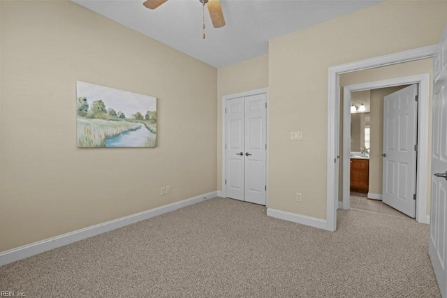 unfurnished bedroom with light carpet, a closet, a ceiling fan, and baseboards