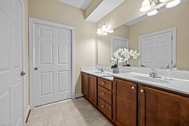 full bath with double vanity, baseboards, tile patterned floors, and a sink