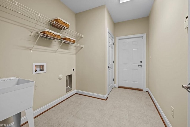 clothes washing area with electric dryer hookup, washer hookup, a sink, baseboards, and laundry area