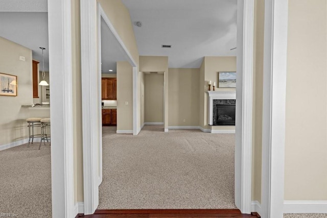 corridor featuring visible vents, baseboards, and carpet floors