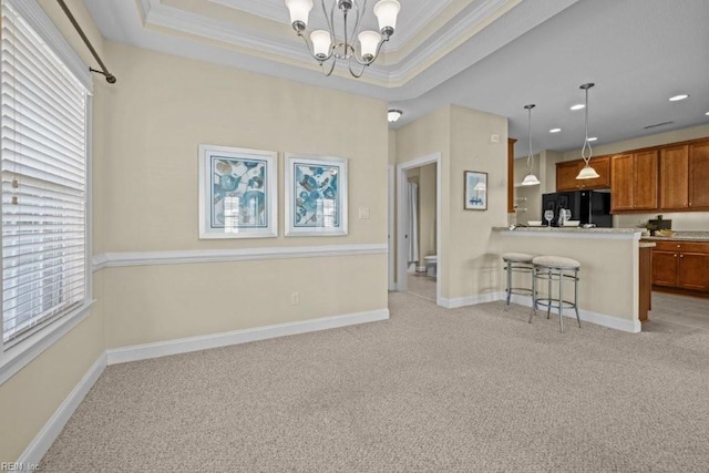 kitchen with a raised ceiling, light carpet, brown cabinetry, and black fridge