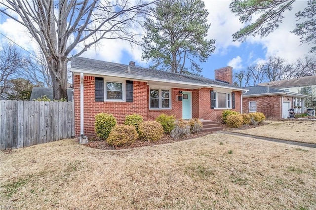 ranch-style house with brick siding, a chimney, a front lawn, and fence