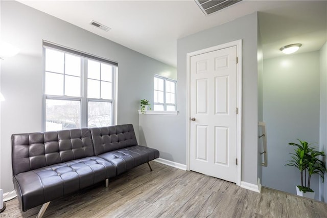 living area with visible vents, baseboards, and wood finished floors