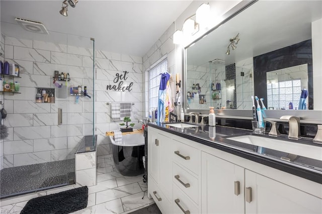 full bath featuring a sink, tile walls, marble finish floor, and a stall shower