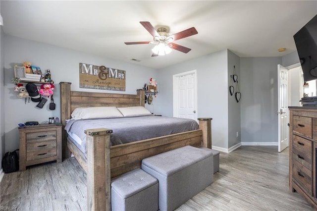 bedroom with visible vents, baseboards, light wood-style flooring, and a ceiling fan