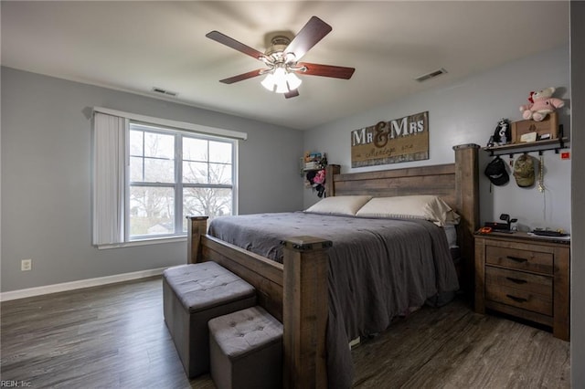 bedroom with visible vents, baseboards, and wood finished floors