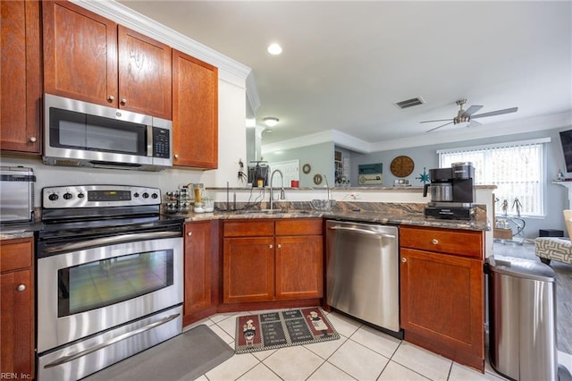 kitchen featuring visible vents, appliances with stainless steel finishes, dark stone counters, and ornamental molding