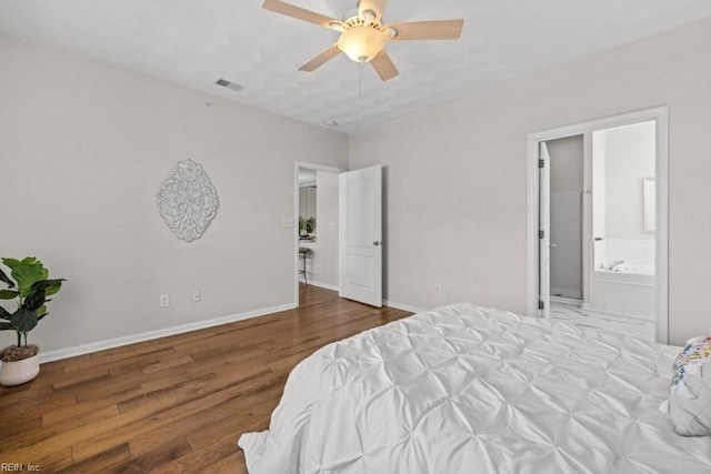 bedroom with visible vents, connected bathroom, ceiling fan, baseboards, and wood finished floors