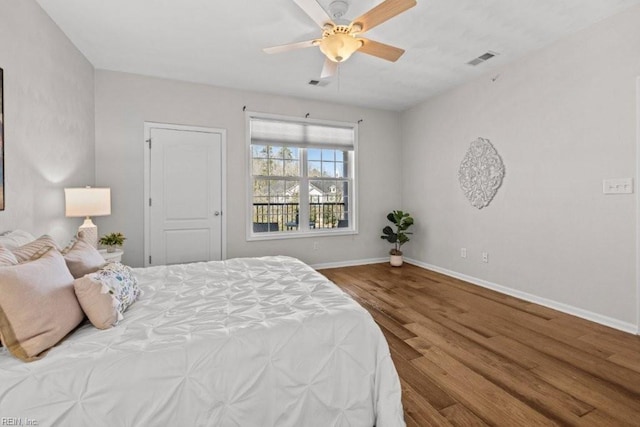 bedroom with wood finished floors, visible vents, and baseboards