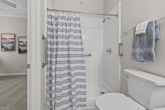 bathroom featuring baseboards, tiled shower, and toilet