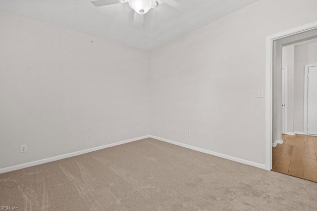 carpeted spare room featuring a ceiling fan and baseboards