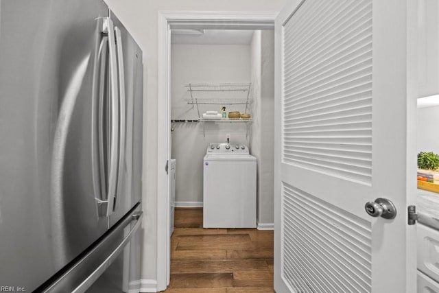 clothes washing area featuring washer / dryer and wood finished floors