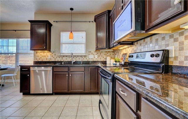 kitchen with light tile patterned flooring, plenty of natural light, a sink, stainless steel appliances, and dark brown cabinets