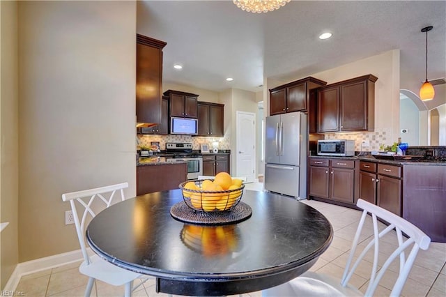 kitchen with tasteful backsplash, baseboards, decorative light fixtures, light tile patterned floors, and appliances with stainless steel finishes