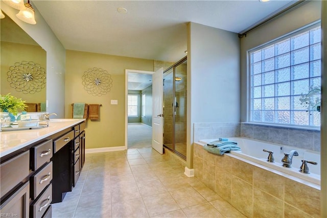 bathroom with tile patterned floors, a garden tub, a stall shower, a sink, and double vanity