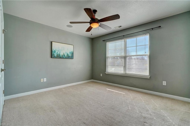 empty room with visible vents, baseboards, carpet flooring, a textured ceiling, and a ceiling fan