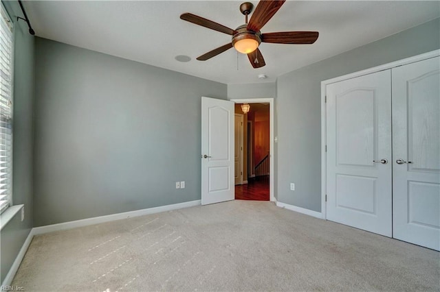 unfurnished bedroom featuring a closet, multiple windows, baseboards, and carpet floors