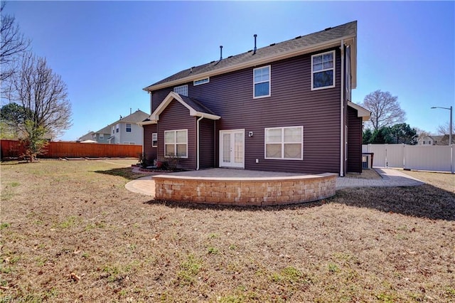 rear view of house with a patio area, a lawn, and a fenced backyard