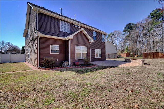 back of house featuring a storage unit, a lawn, a patio, a fenced backyard, and an outdoor structure