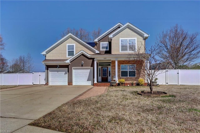 view of front of property with driveway, an attached garage, fence, and a gate