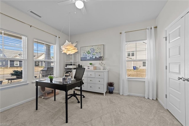 office area with light carpet, visible vents, a ceiling fan, and baseboards