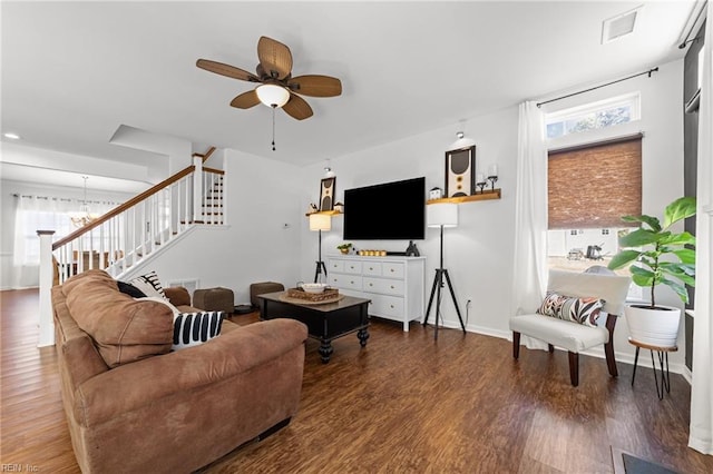 living area with visible vents, wood finished floors, baseboards, ceiling fan, and stairs