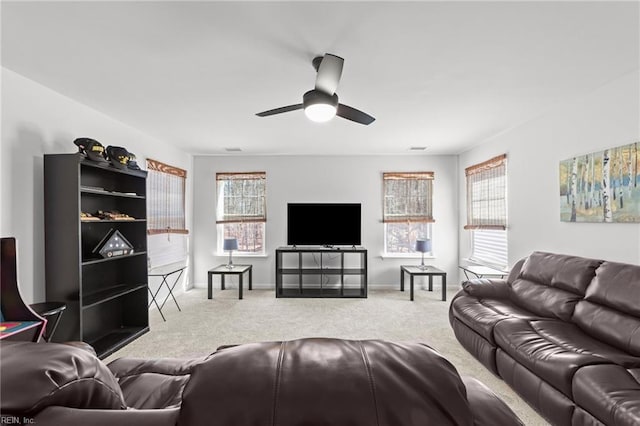 living area featuring a ceiling fan, baseboards, and carpet floors