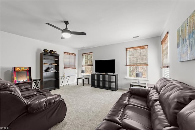 living area with visible vents, carpet floors, baseboards, and a ceiling fan