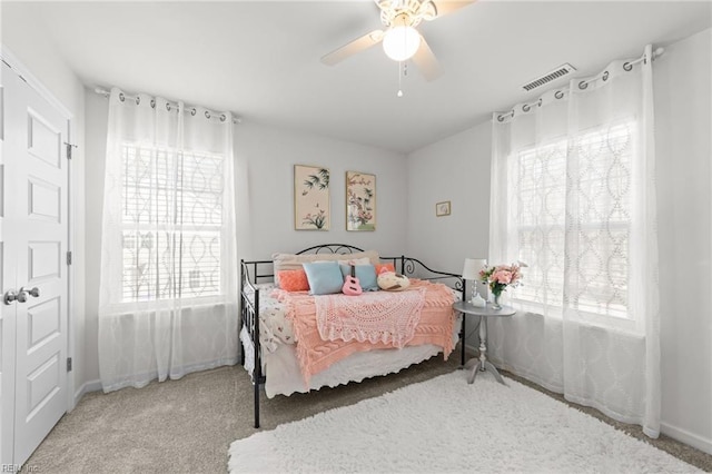 bedroom featuring visible vents, baseboards, ceiling fan, and carpet floors